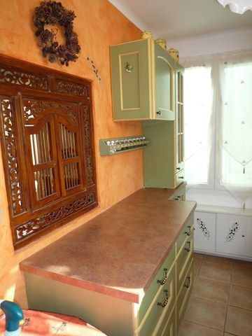 Installation d'un cuisine rustique à LA CIOTAT (13) Modèle GEVAUDAN façade en chêne massif ép 21 mm fond vert rechampi tournesol